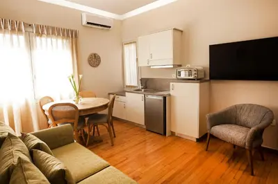 a living room with a couch and a table and a kitchen at Bentzi Boutique Apartment 4 in Athens