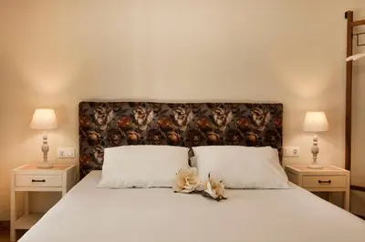 a bedroom with a bed with white sheets and two lamps at Bentzi...Boutique Apartment 6, Superior Suite for 4 Guests in Athens