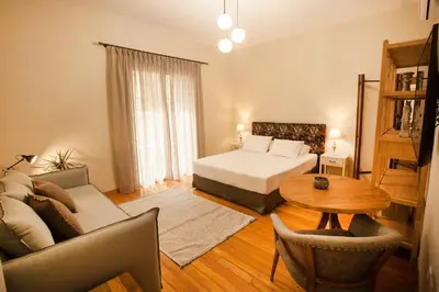 a bedroom with a bed and a couch and a table at Bentzi...Boutique Apartment 6, Superior Suite for 4 Guests in Athens