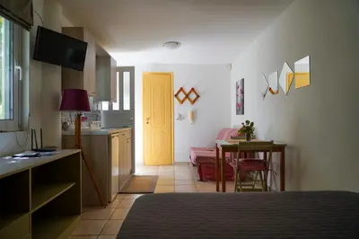 a room with a kitchen and a yellow door at Cosy guest house with private yard in Saronida