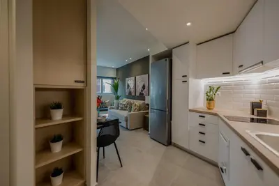 a kitchen with a sink and a living room at Living Stone Amazonit in Athens