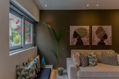a living room with a couch and a window at Living Stone Amazonit in Athens