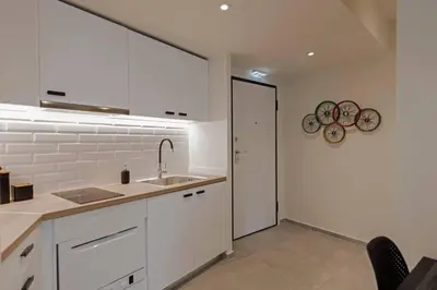 a kitchen with white cabinets and a sink at Living Stone Amazonit in Athens