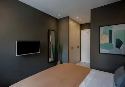 a bedroom with a bed and a flat screen tv at Living Stone Amazonit in Athens