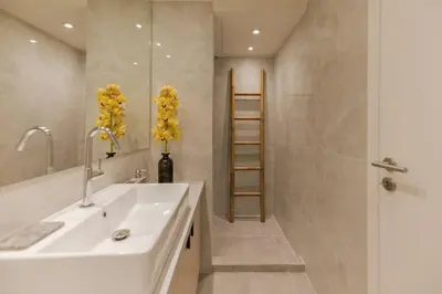 a bathroom with a sink and a shower with yellow flowers at Living Stone Amazonit in Athens