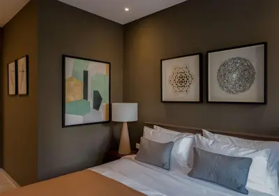 a bedroom with a bed with four pictures on the wall at Living Stone Amazonit in Athens