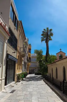 an empty street with a palm tree in the distance at Plato's Square Apartments in Athens