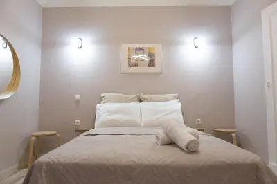 a bedroom with a large bed with white pillows at Plato's Square Apartments in Athens