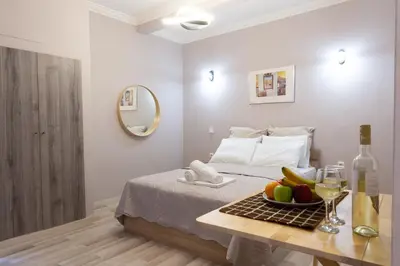 a bedroom with a bed and a table with a bowl of fruit at Plato's Square Apartments in Athens