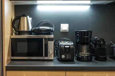 a kitchen counter with a microwave and various appliances at Modern 5BD Apartment in the Heart of Athens in Athens