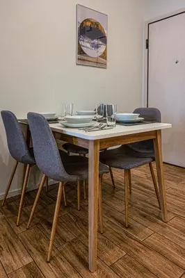 a table with chairs and plates and glasses on it at Modern 5BD Apartment in the Heart of Athens in Athens