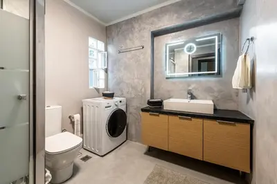 a bathroom with a sink and a washing machine at Modern 5BD Apartment in the Heart of Athens in Athens