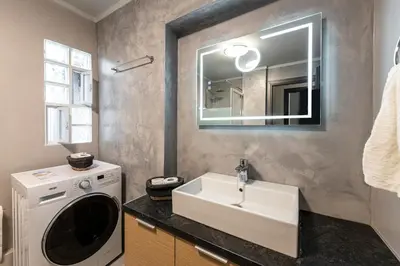 a bathroom with a sink and a washing machine at Modern 5BD Apartment in the Heart of Athens in Athens