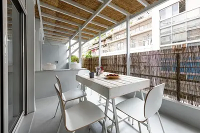 a table and chairs in a room with a large window at Modern 5BD Apartment in the Heart of Athens in Athens