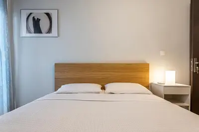 a bedroom with a large bed with a wooden headboard at Modern 5BD Apartment in the Heart of Athens in Athens