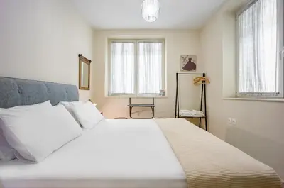 a white bed in a bedroom with two windows at Bentzi...Boutique Apartment 1, Classic Double with kitchenette, 2 Guests in Athens