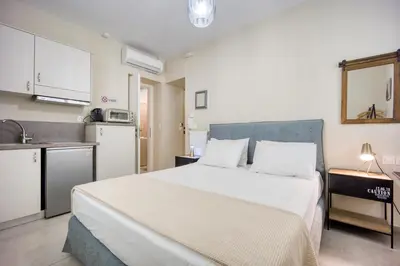 a bedroom with a large bed and a kitchen at Bentzi...Boutique Apartment 1, Classic Double with kitchenette, 2 Guests in Athens