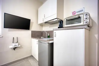 a small kitchen with a microwave on top of a refrigerator at Bentzi...Boutique Apartment 1, Classic Double with kitchenette, 2 Guests in Athens