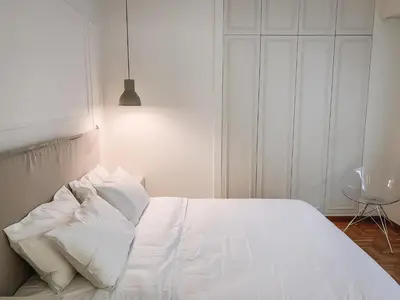 a white bed with white pillows in a bedroom at API Projects Kolonaki - Casa Academia in Athens