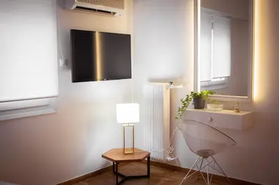 a room with a lamp and a television on a wall at API Projects Kolonaki - Casa Academia in Athens