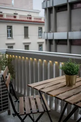 a wooden table with a potted plant on a balcony at API Projects Kolonaki - Casa Academia in Athens