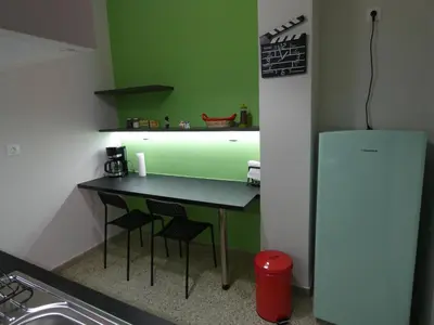 a small kitchen with a table and a refrigerator at Cinema Lovers in Athens