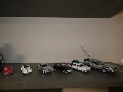 a group of toy cars sitting on a shelf at Cinema Lovers in Athens