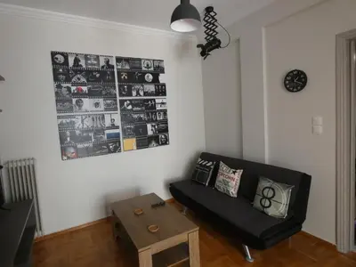 a living room with a black couch and a table at Cinema Lovers in Athens