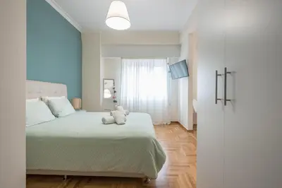 a bedroom with a bed with a teddy bear on it at Paris & Helen in Athens