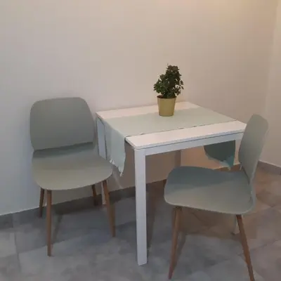 two chairs and a white table with a plant on it at Paris & Helen in Athens