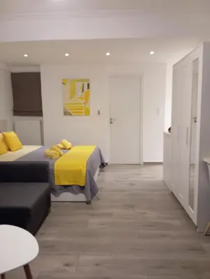 a bedroom with two beds with yellow sheets at Kolonaki Luxury backyard Studio in Athens