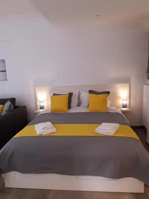 a bedroom with a large bed with yellow pillows at Kolonaki Luxury backyard Studio in Athens
