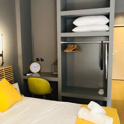 a room with a bed and a stack of towels at Metropolitan Complex Suite 2@faliro in Piraeus