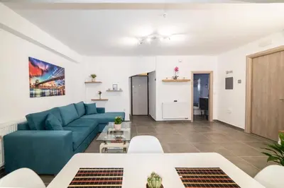a living room with a blue couch and a table at Brand New Aprt with backyard in Lycabettus Hill ! in Athens