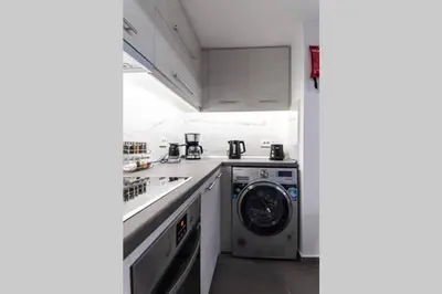 a kitchen with a washing machine and a washer at Brand New Aprt with backyard in Lycabettus Hill ! in Athens