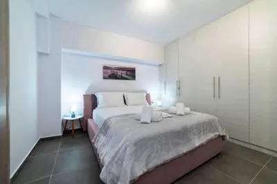 a bedroom with a large bed with white cabinets at Brand New Aprt with backyard in Lycabettus Hill ! in Athens