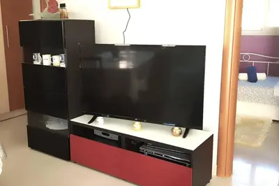 a large flat screen tv on a stand in a room at Renovated lovely apartment near airport & sea in Porto Rafti