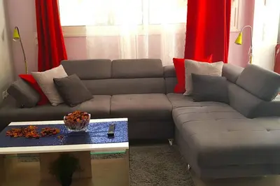 a living room with a couch and a table at Renovated lovely apartment near airport & sea in Porto Rafti