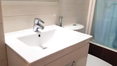 a bathroom with a white sink and a toilet at Renovated lovely apartment near airport & sea in Porto Rafti