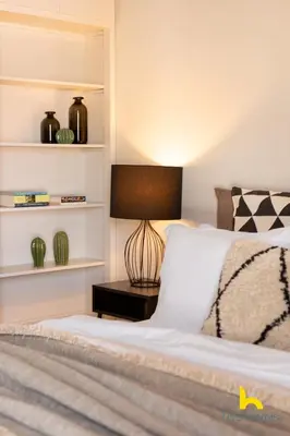 a bedroom with a bed with a lamp on a table at Penthouse with Magical Acropolis view from Balcony in Athens