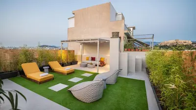 a patio with furniture and grass on a roof at Penthouse with Magical Acropolis view from Balcony in Athens