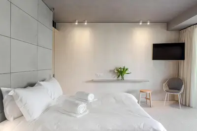 a bedroom with a white bed with towels on it at Ogarden in Athens