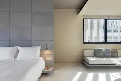 a bedroom with a bed and a couch and a window at Ogarden in Athens
