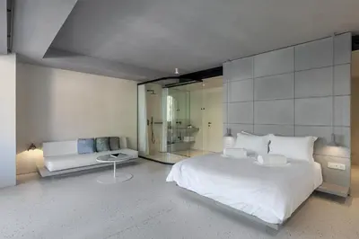 a bedroom with a large white bed and a couch at Ogarden in Athens