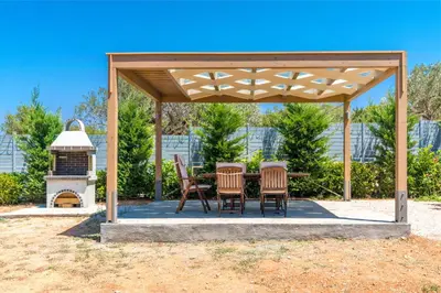 a wooden pavilion with a table and chairs and a fireplace at Your Home2b in Paianía