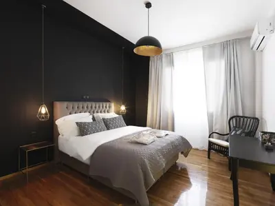 a bedroom with a large bed with a black wall at Athenian Apartment in the center with Jacuzzi in Athens