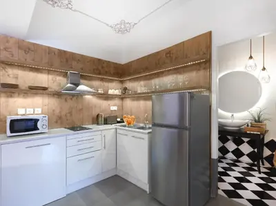 a kitchen with white cabinets and a stainless steel refrigerator at Athenian Apartment in the center with Jacuzzi in Athens