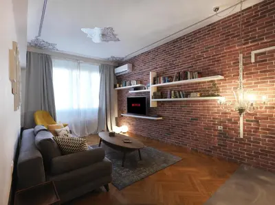a living room with a brick wall and a couch at Athenian Apartment in the center with Jacuzzi in Athens
