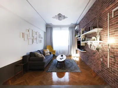 a living room with a couch and a brick wall at Athenian Apartment in the center with Jacuzzi in Athens