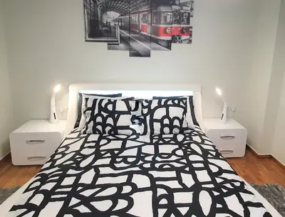 a bedroom with a bed with a black and white comforter at WHITE HOUSE 30 steps from the Metro station in Athens